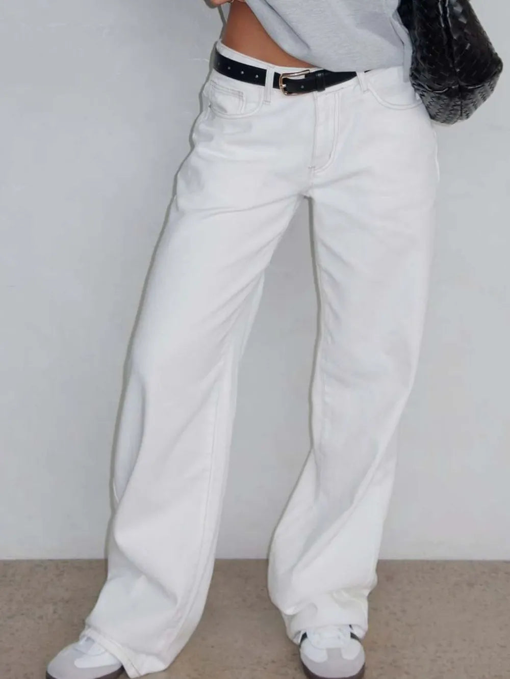 White pants worn by a person against a plain background