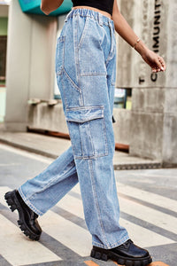 Person wearing blue jeans and black shoes walking on a street.