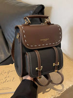 Brown leather backpack with gold accents on a neutral background