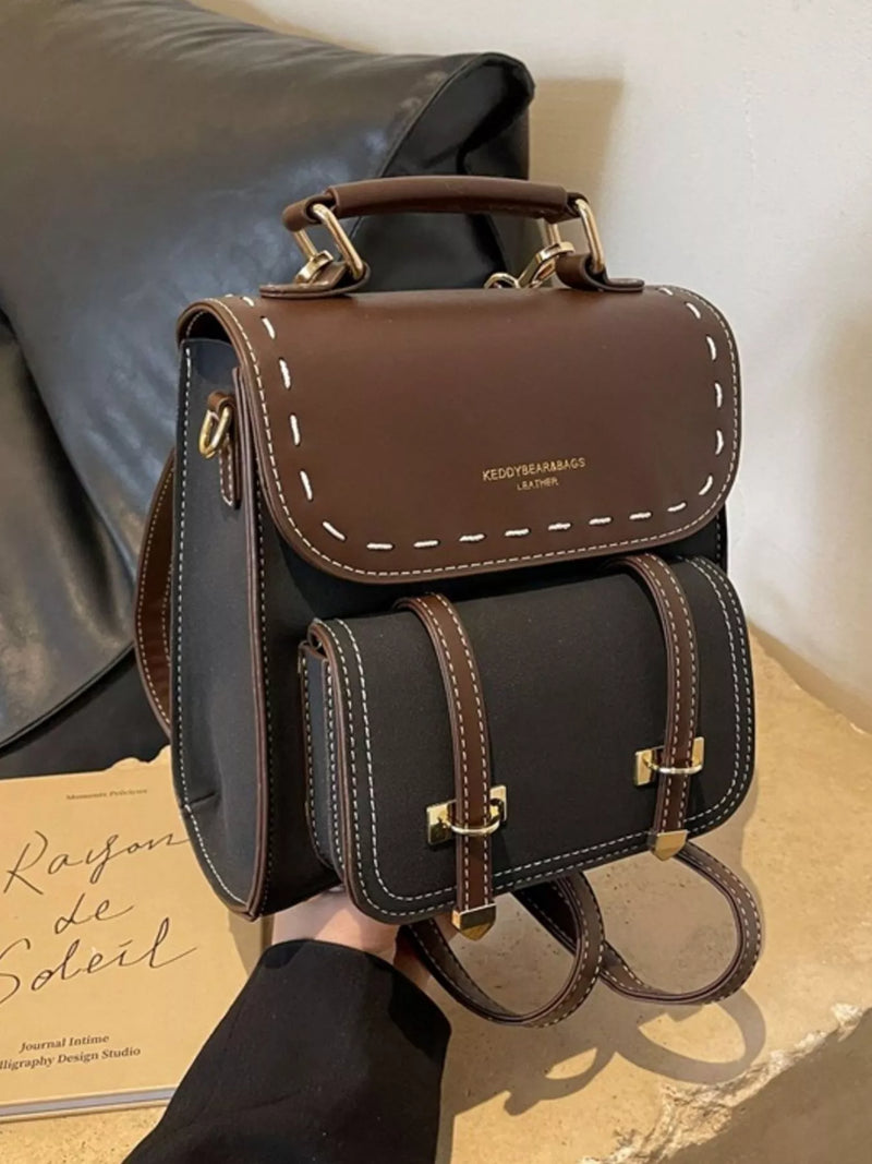 Brown leather backpack with gold accents on a neutral background