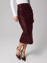 Burgundy satin skirt worn by a person on a gray background
