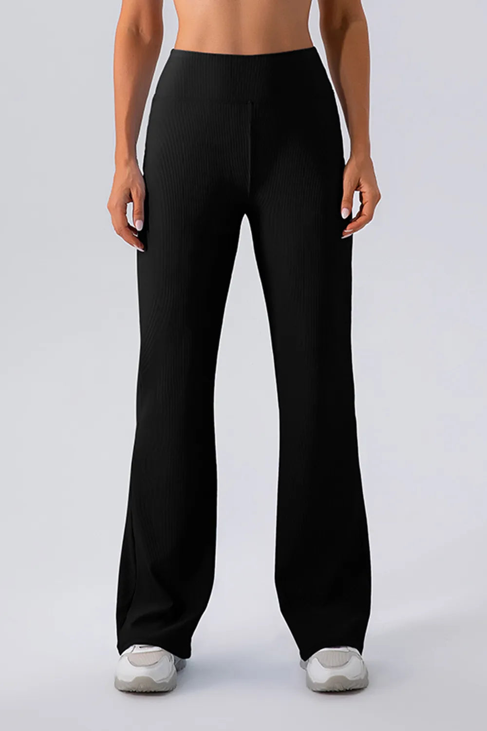 Person wearing black wide-leg pants on a plain background
