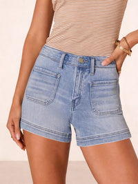 Person wearing light blue denim shorts and a beige striped top on a beige background