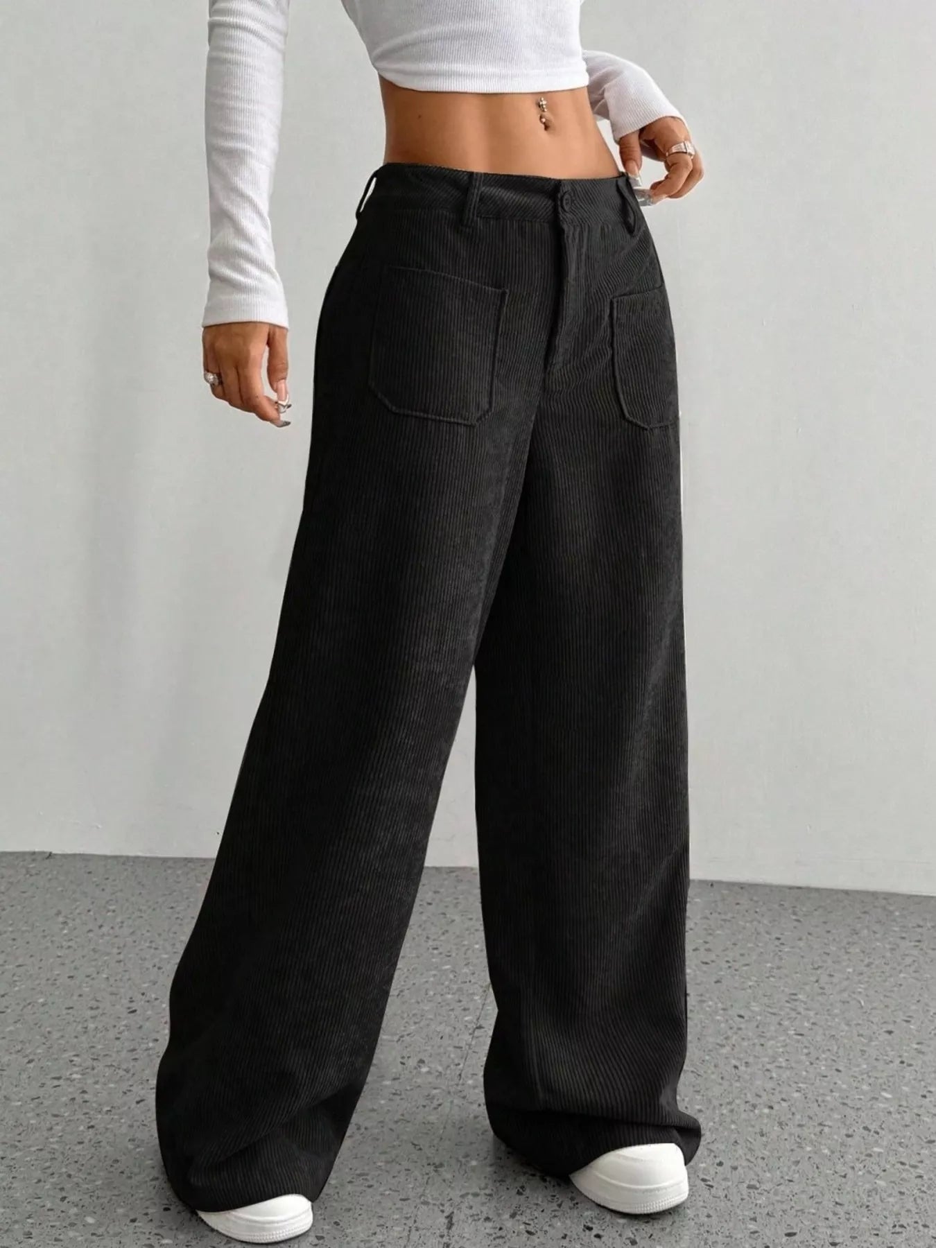 Person wearing black wide-leg pants on a plain background