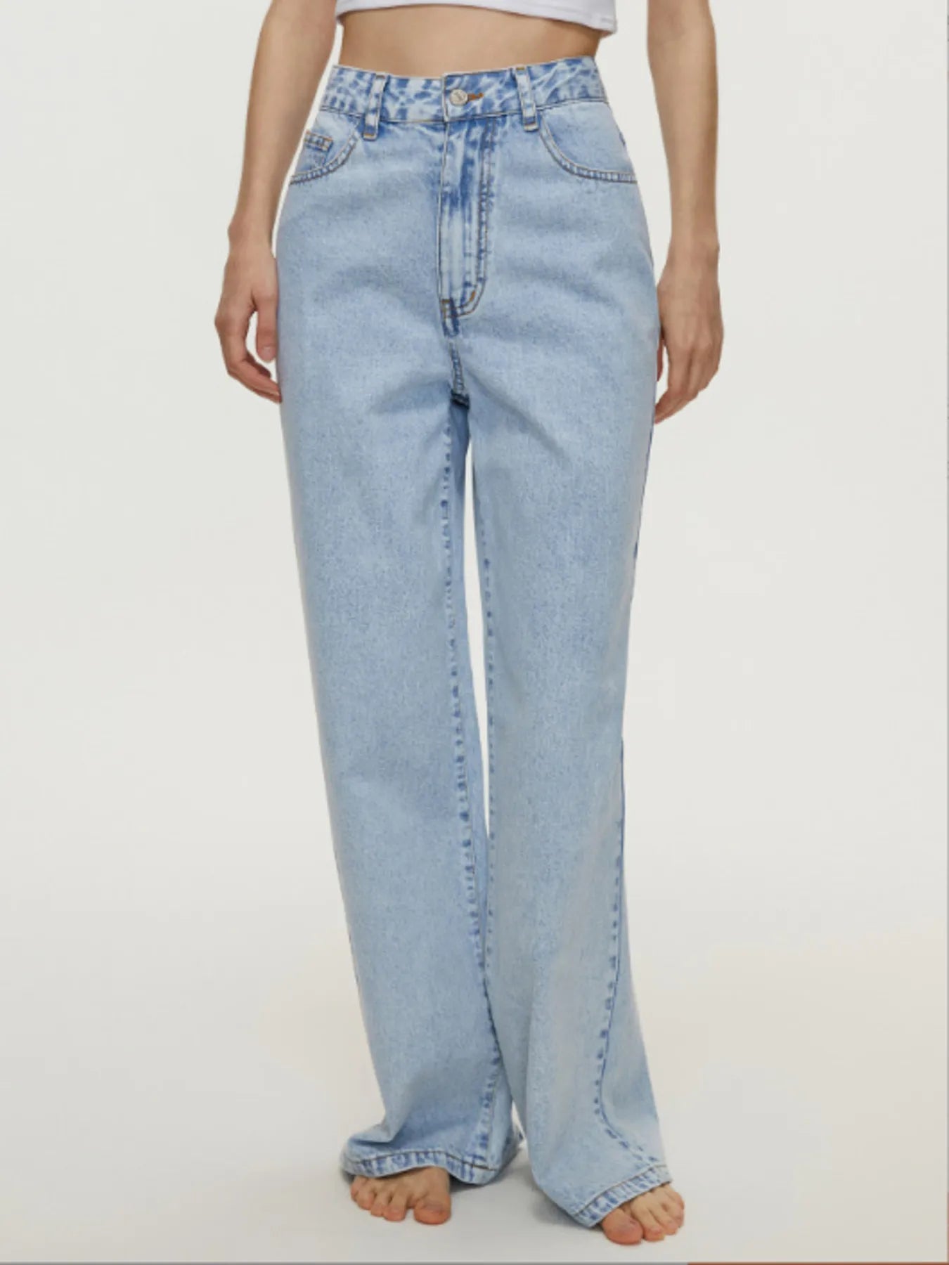 Light blue jeans worn by a person on a white background
