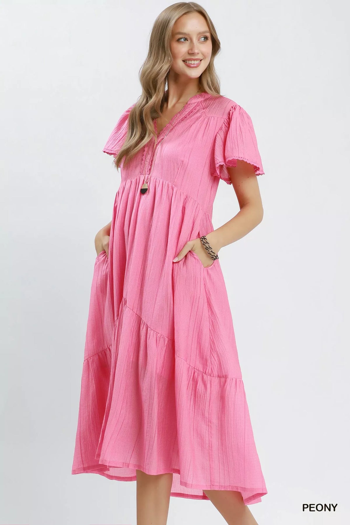 Woman wearing a pink dress with short sleeves on a white background