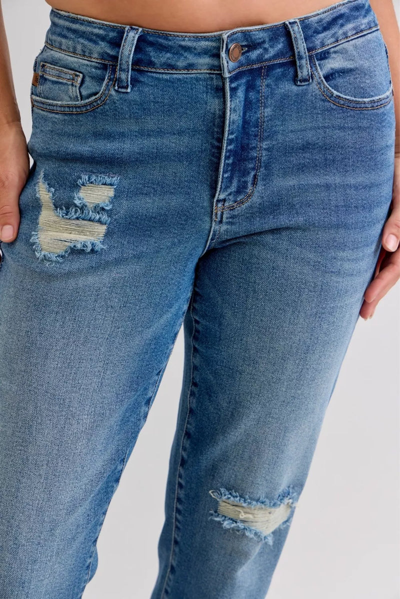Blue jeans with slight distressing on a plain background