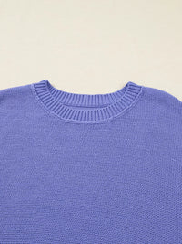 Close-up of a blue sweater with a beige background