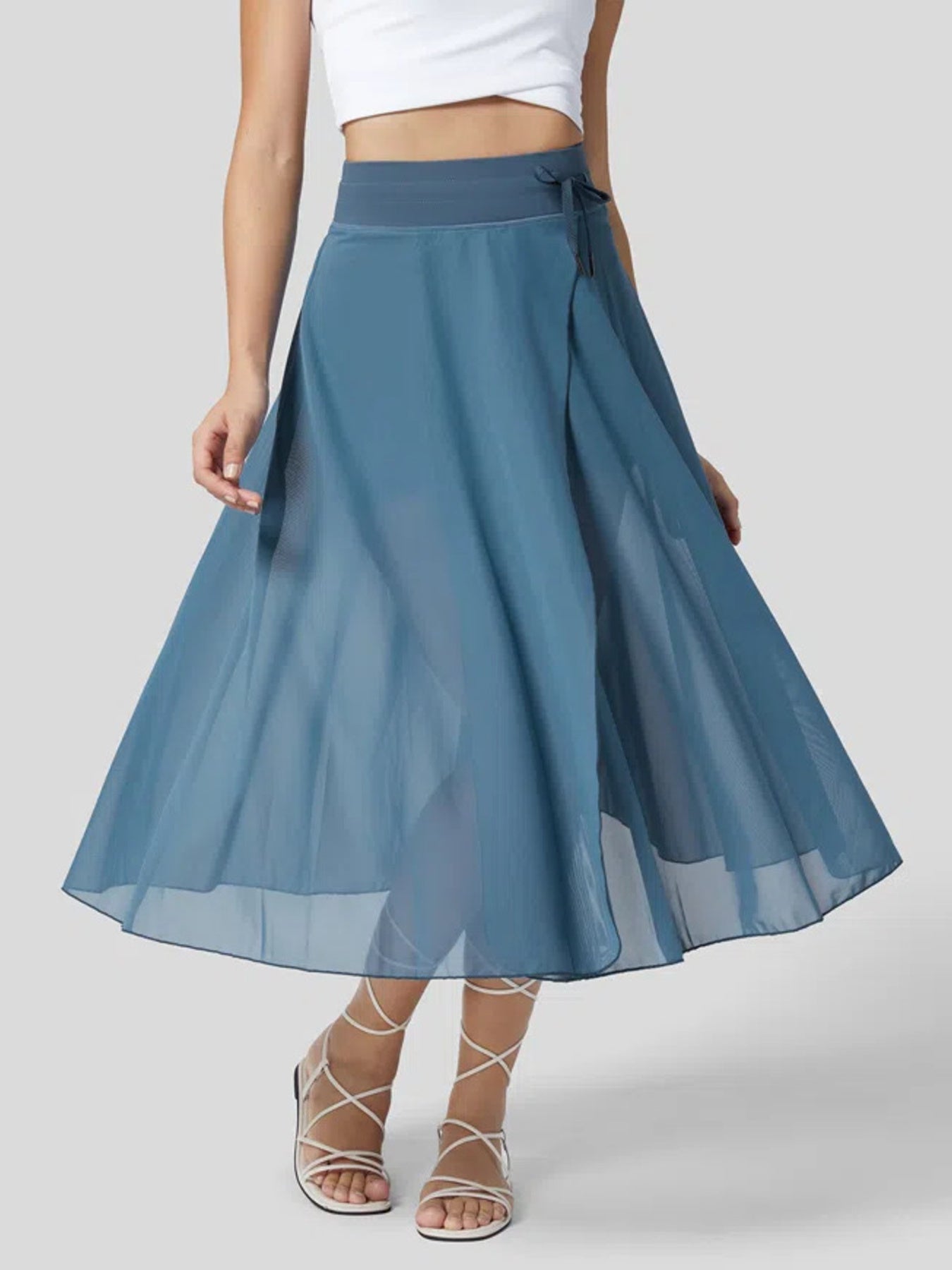 Blue skirt worn by a person on a plain background