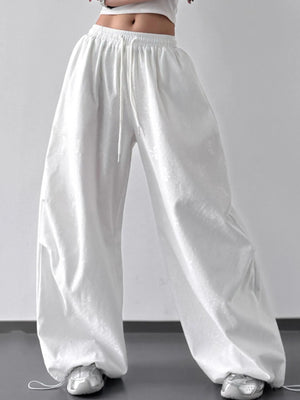 White wide-leg pants worn by a person on a plain background