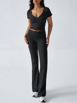 Woman wearing a black outfit with a top and wide-leg pants on a white background