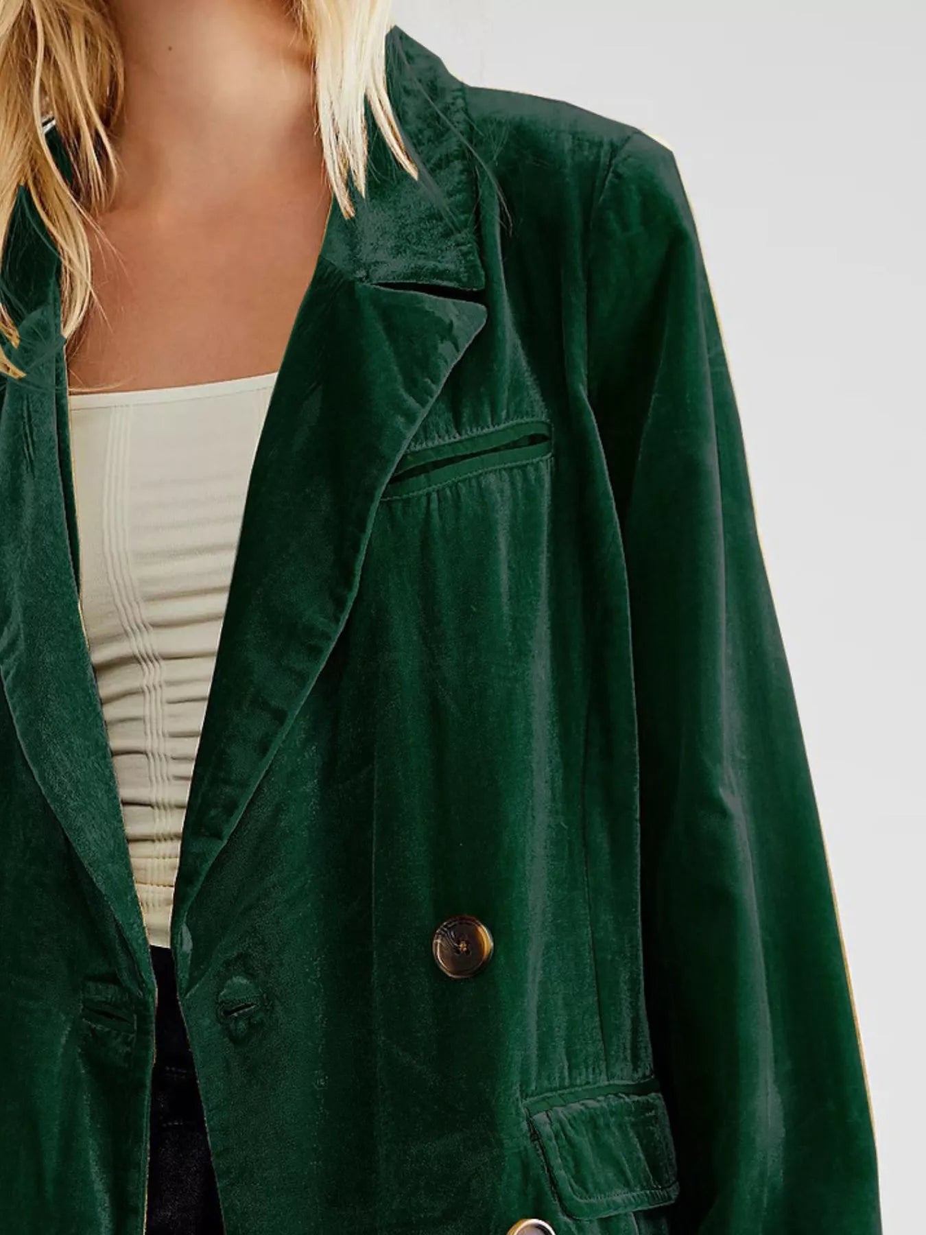 Green jacket worn by a person on a plain background