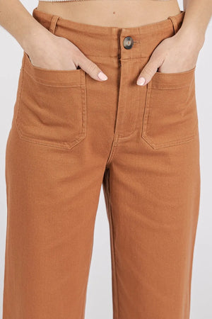 Brown pants worn by a person on a white background