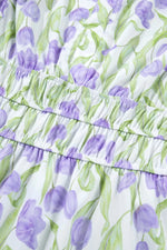 Close-up of a dress with purple tulip pattern on a white background