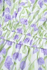 Close-up of a dress with purple tulip pattern on a white background