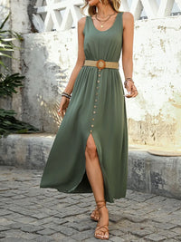 Woman wearing a green dress with a belt, standing on a stone path.