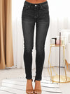 Black jeans worn by a person in a minimal indoor setting