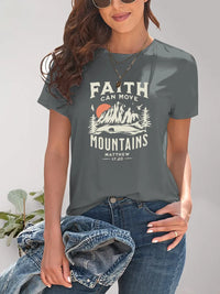 Person wearing a gray t-shirt with 'Faith Can Move Mountains' design, holding jeans.
