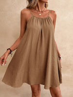 Woman wearing a brown dress against a beige background