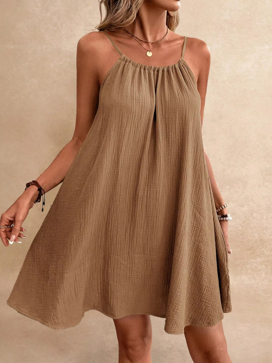 Woman wearing a brown dress against a beige background