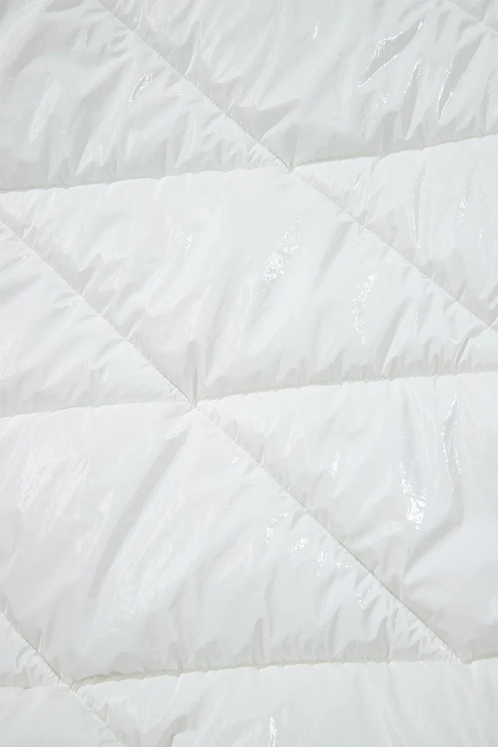 Close-up of a white quilted comforter with diamond pattern