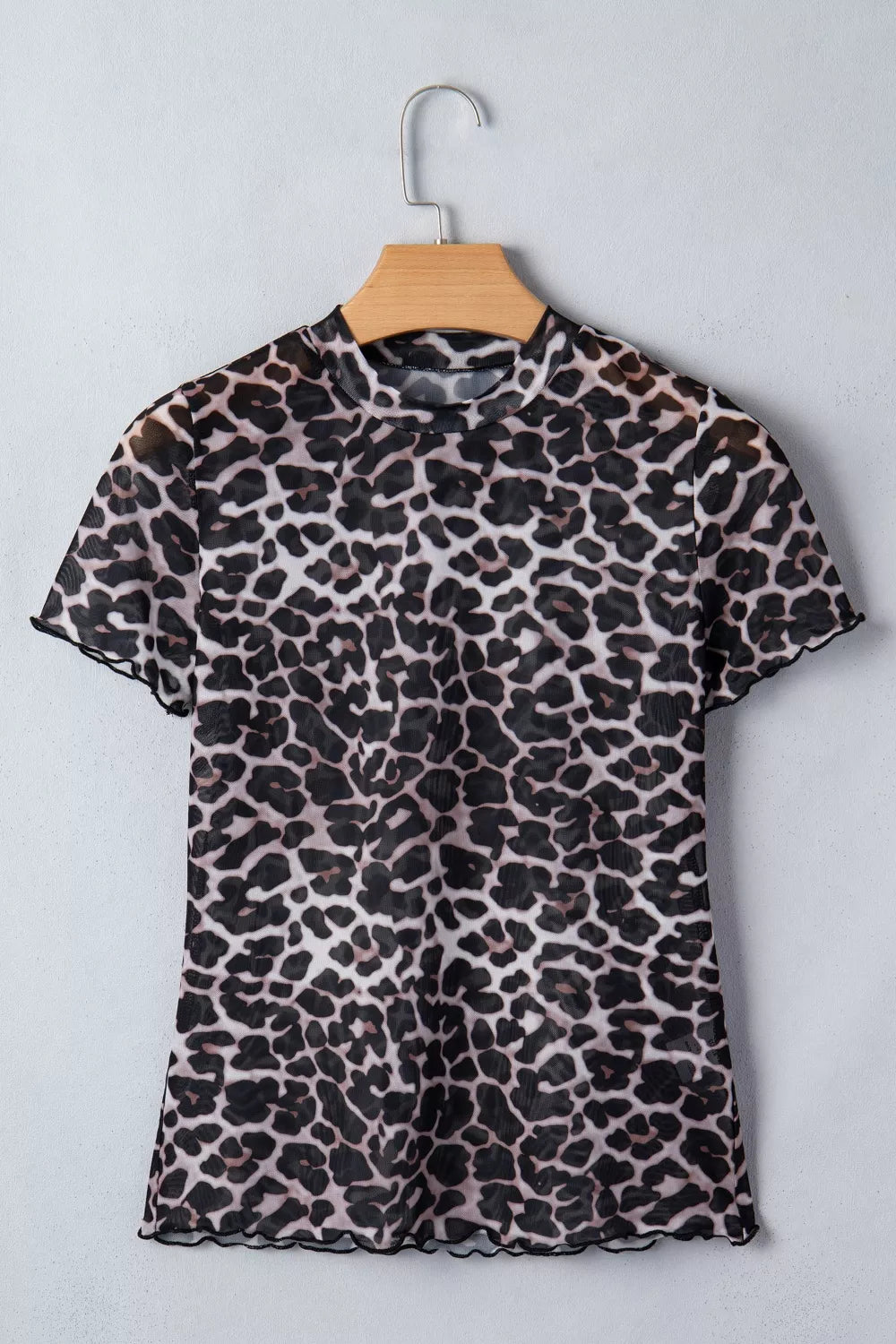 Leopard print dress on a hanger against a light gray background
