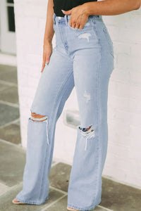 Light blue distressed jeans worn by a person on a neutral background