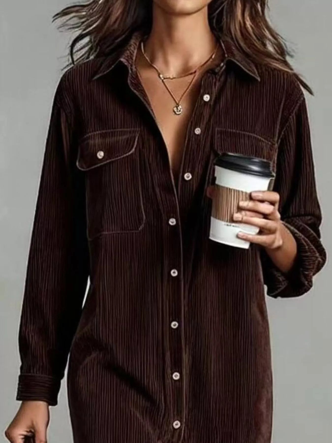 Person wearing a brown corduroy shirt holding a coffee cup against a gray background