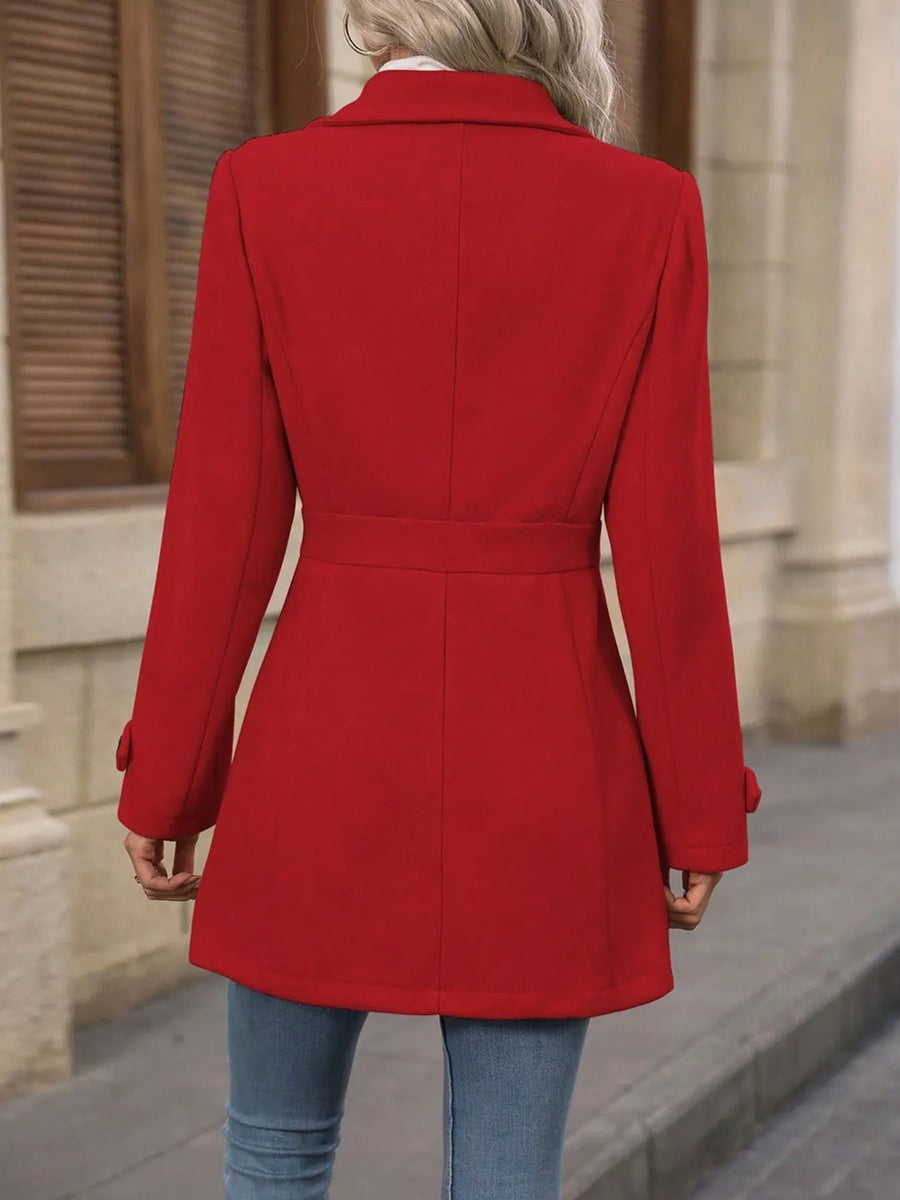 Person wearing a red coat with a neutral background
