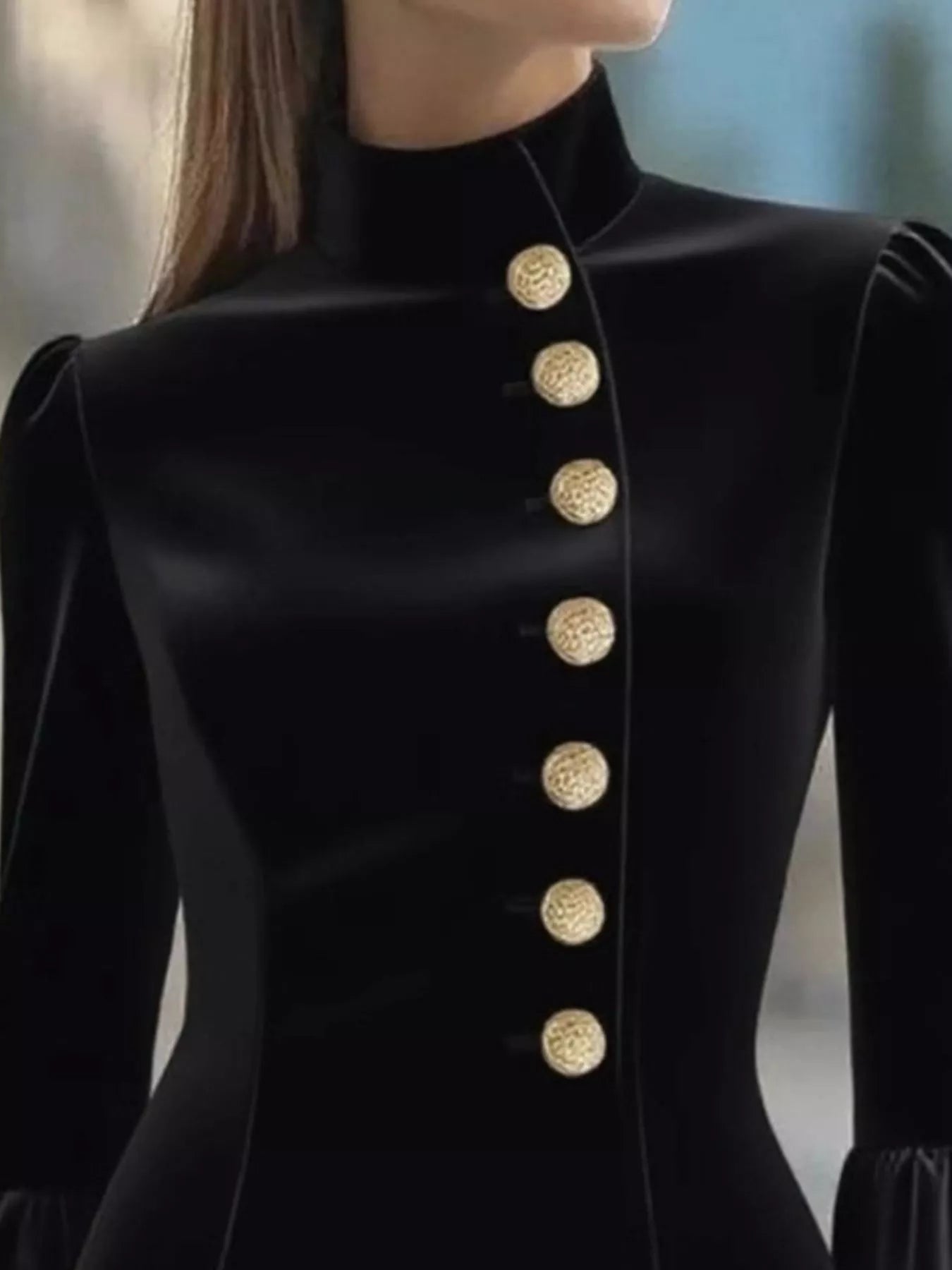 Black coat with gold buttons on a blurred background