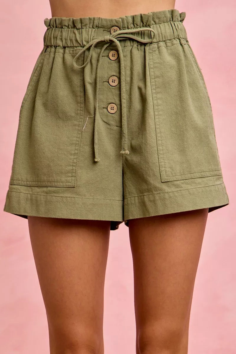 Green shorts with buttons on a pink background