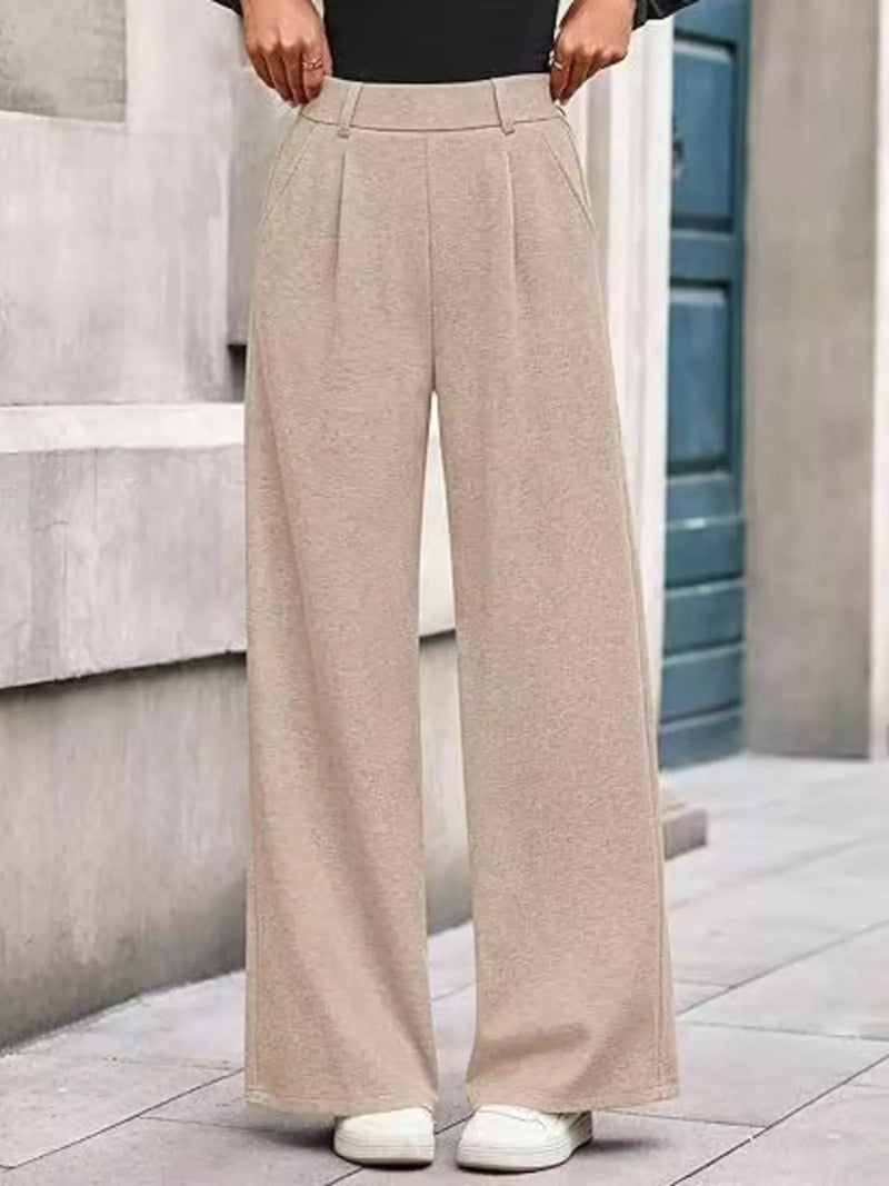 Beige wide-leg pants worn by a person on a stone staircase.
