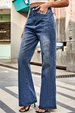 Person wearing blue flared jeans on a city street.