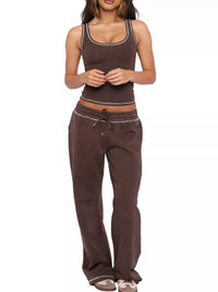Woman wearing a brown tank top and pants on a white background