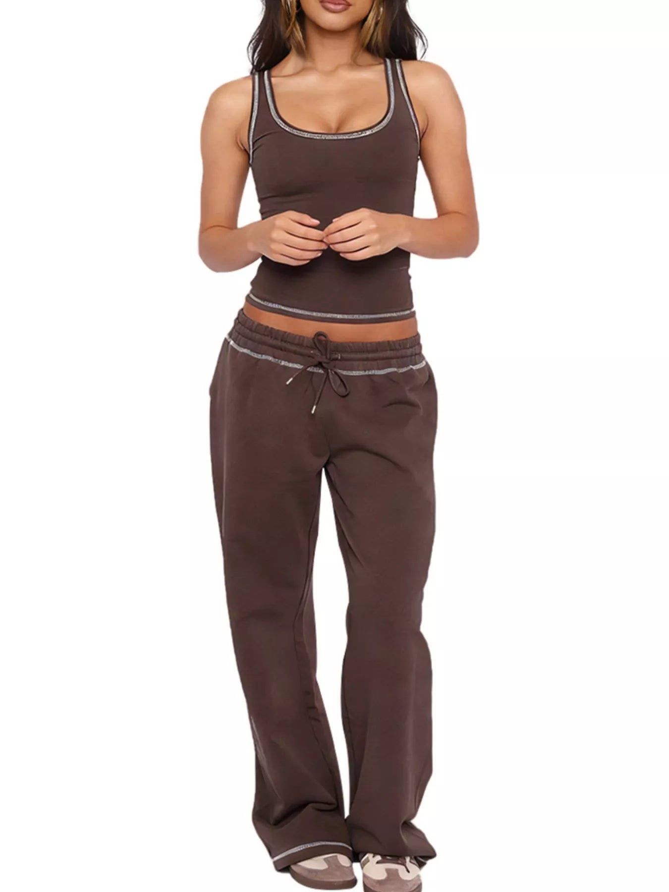 Woman wearing a brown tank top and pants on a white background