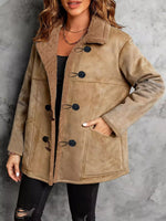 Woman wearing a beige shearling coat with black buttons against a gray background