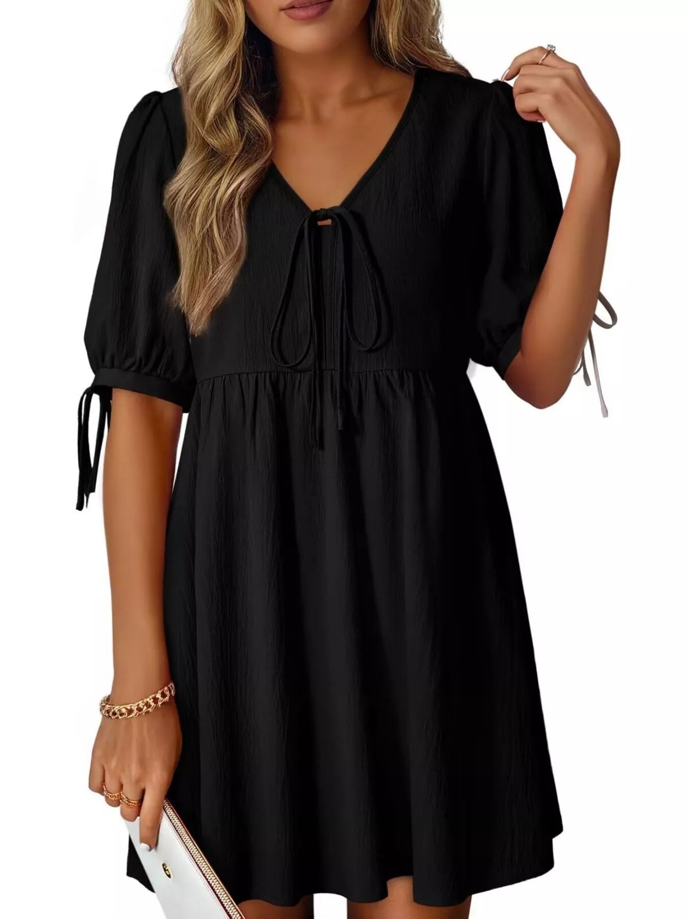 Black dress with puff sleeves worn by a model on a white background