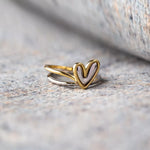 Gold heart-shaped ring on a textured stone surface