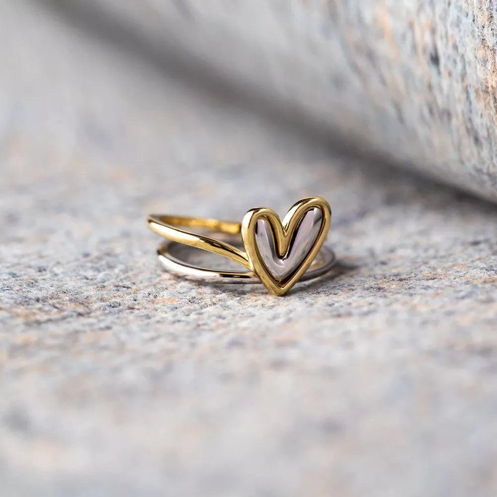 Gold heart-shaped ring on a textured stone surface