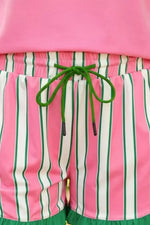 Pink and green striped shorts with a pink top, close-up view.