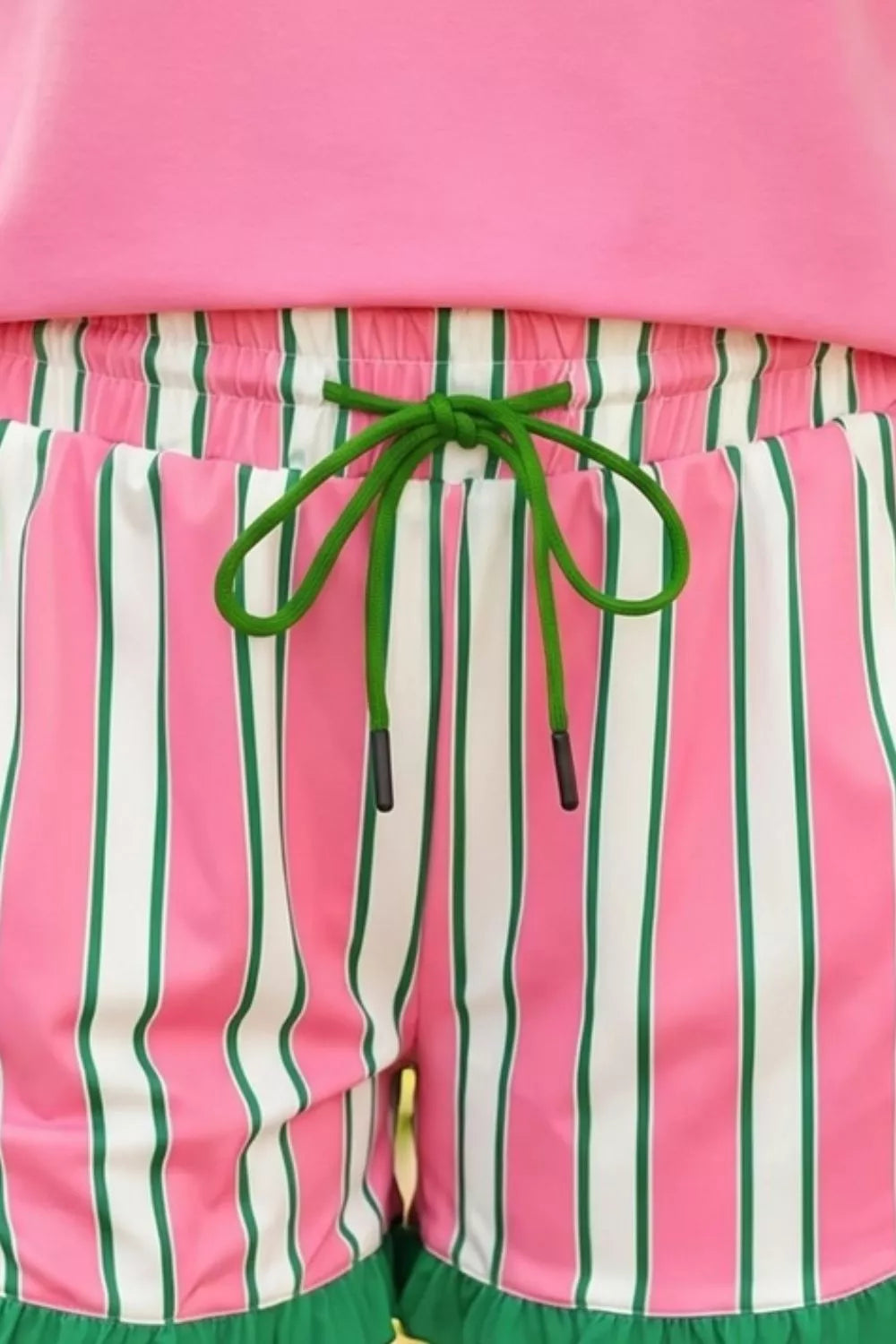 Pink and green striped shorts with a pink top, close-up view.