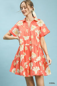 Woman wearing a coral floral dress against a light blue background