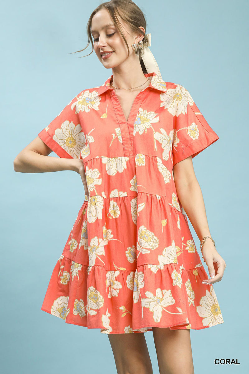 Woman wearing a coral floral dress against a light blue background
