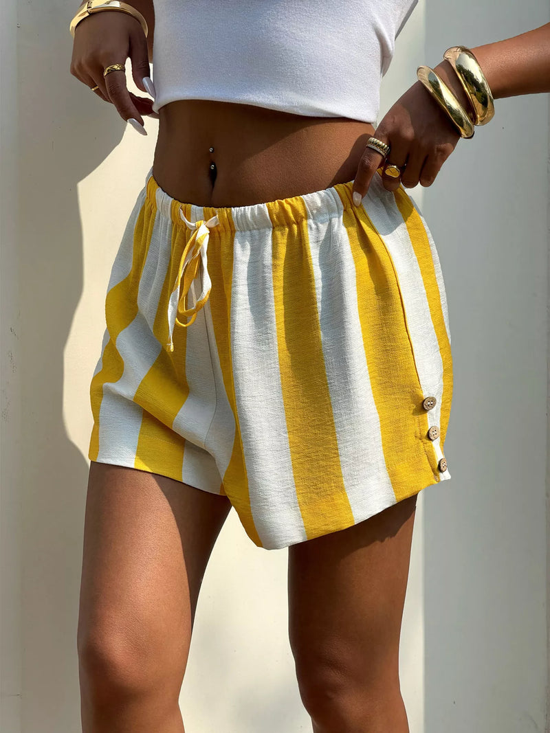 Person wearing yellow and white striped shorts with a plain background