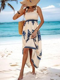 Woman in a beach dress with a straw hat and bag on a tropical beach.