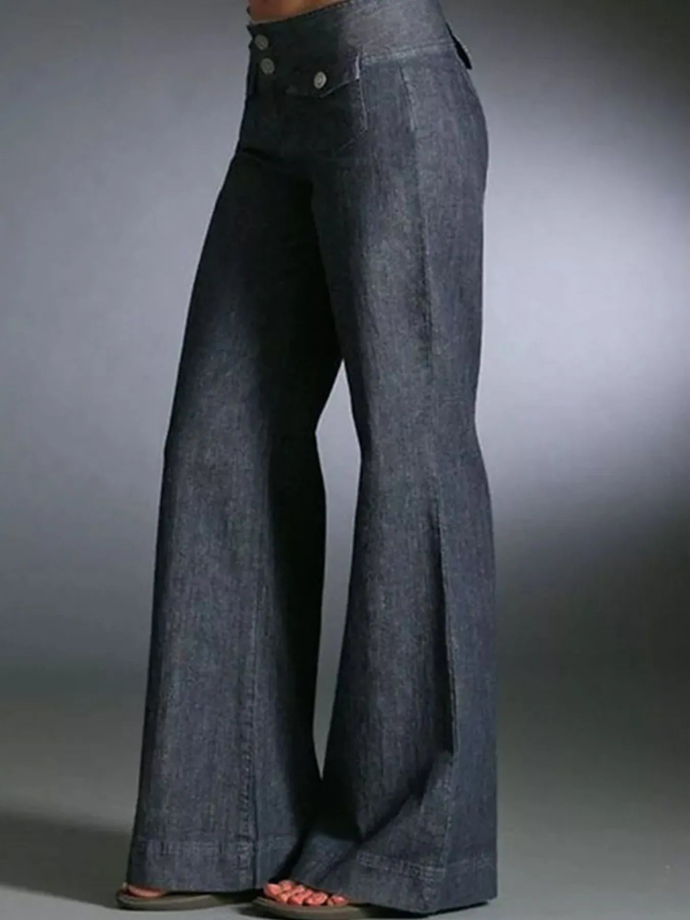 Blue denim bell-bottom pants on a gray background