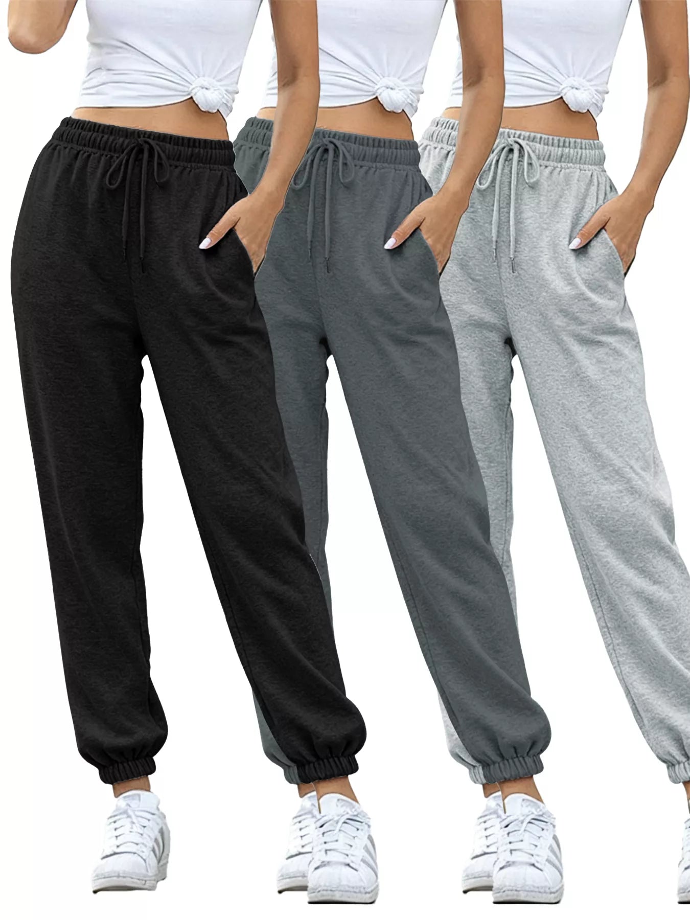 Three pairs of sweatpants in black, gray, and light gray worn by a person on a white background.