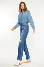 Woman wearing a blue denim jacket and jeans on a white background