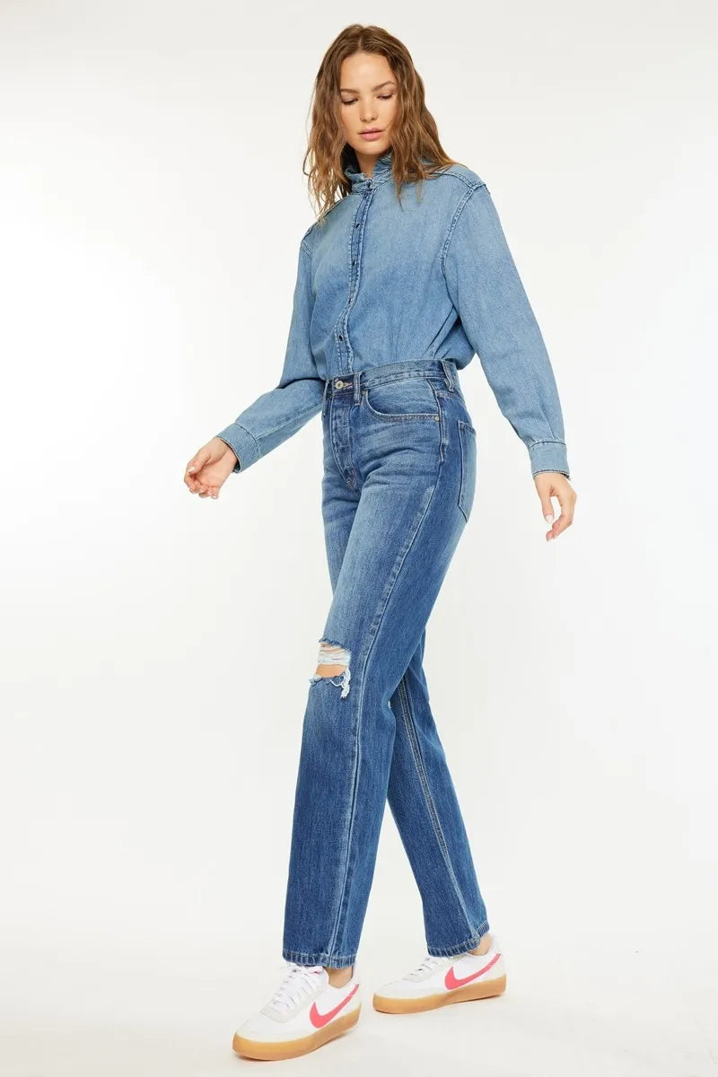 Woman wearing a blue denim jacket and jeans on a white background