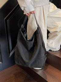 Person holding a black handbag in an indoor setting